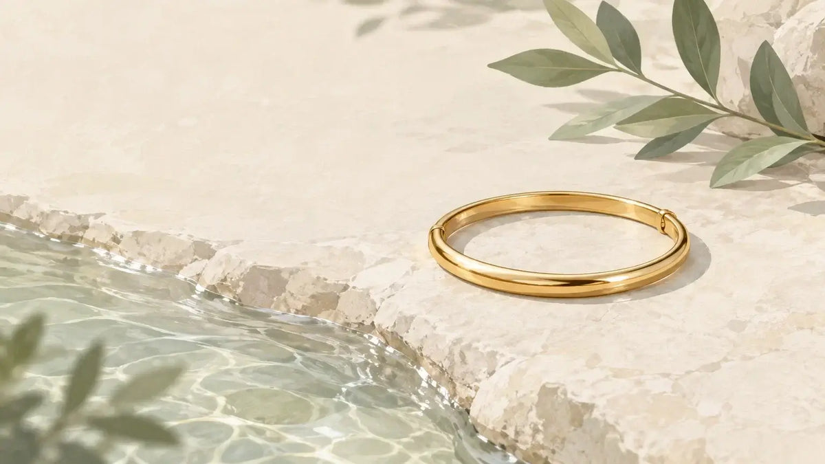 Bracelet doré près de quelques gouttes d’eau