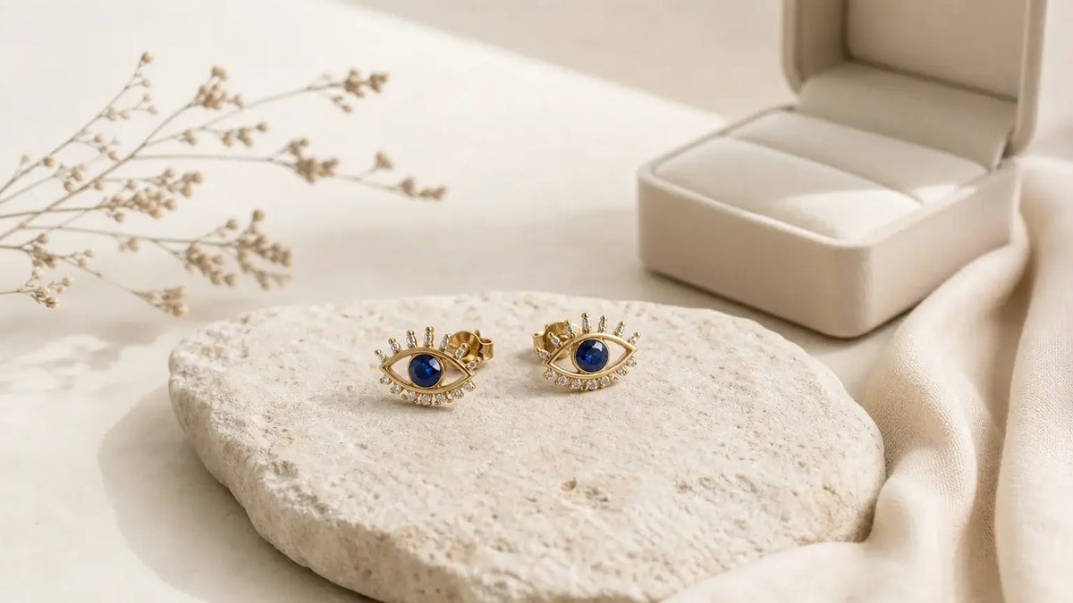 Paire de boucles d'oreilles œil présentée dans un décor naturel