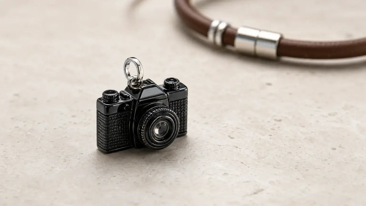 Charm appareil photo noir présenté sur une surface claire