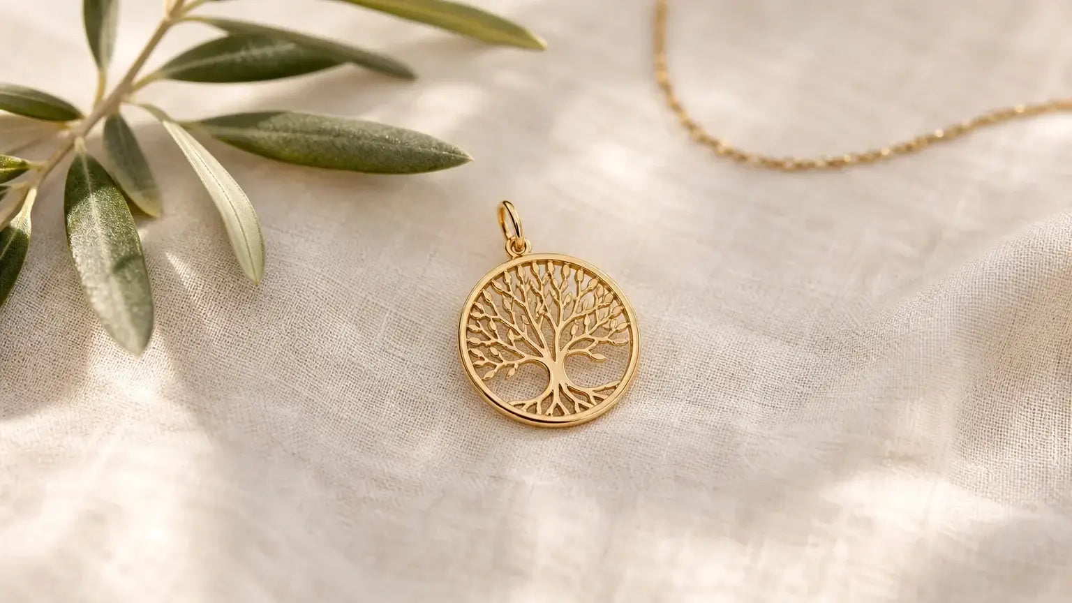 Charm arbre de vie doré posé sur un tissu naturel