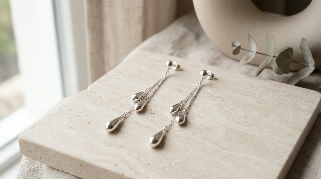 Boucles d'oreilles pendantes en argent sur fond clair épuré