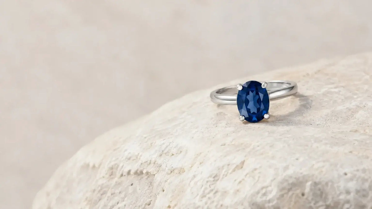 Bague ornée d’une pierre bleue posée sur une pierre claire