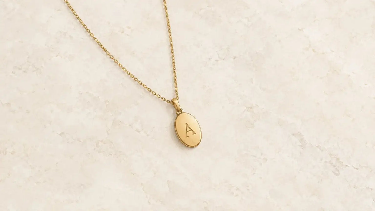 Collier à médaille gravée posé sur un fond clair