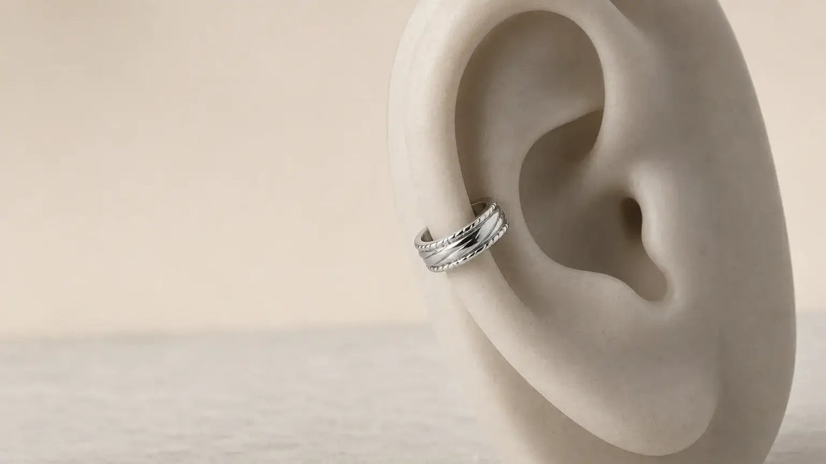 Ear cuff argent présenté en gros plan sur un support neutre