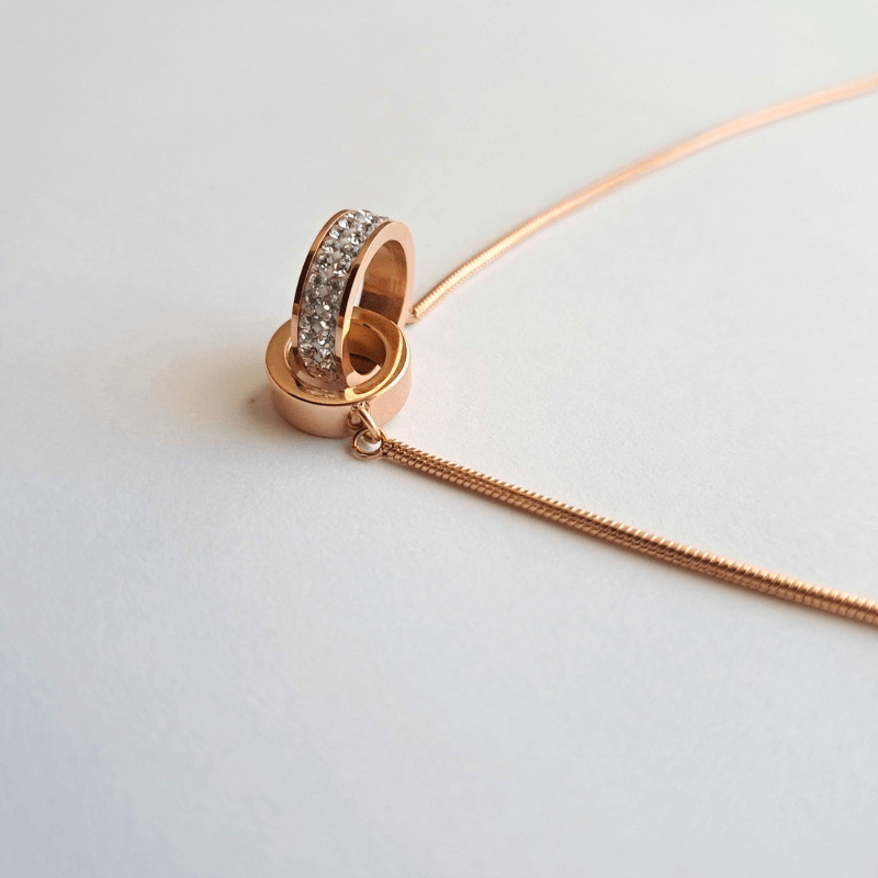 Collier acier doré rose avec 2 cercles entrelacés dont 1 orné de cristaux
